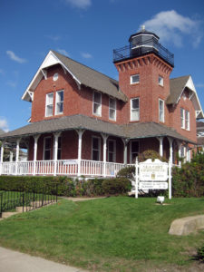 A large red house with a white roof and a lighthouse.