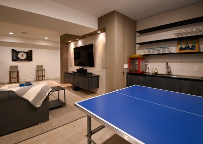 A room with a ping pong table and a couch