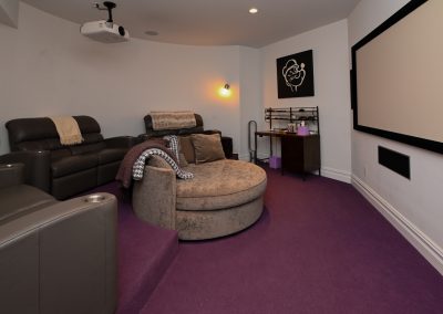 A living room with purple carpet and a projector