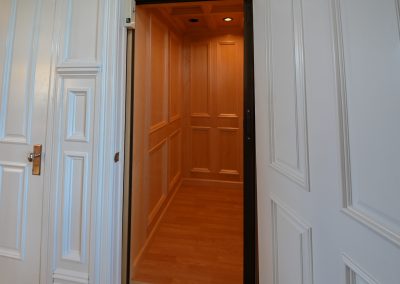 A door way with wood paneling and wooden floors.