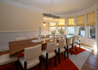 A large dining room table with white chairs
