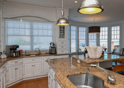A kitchen with granite counter tops and white cabinets.