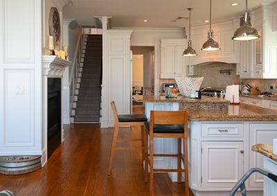 A kitchen with wooden floors and white cabinets.