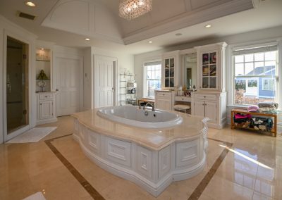 A large bathroom with a tub and cabinets