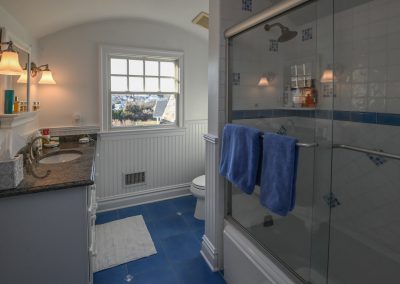 A bathroom with blue tile and white walls.