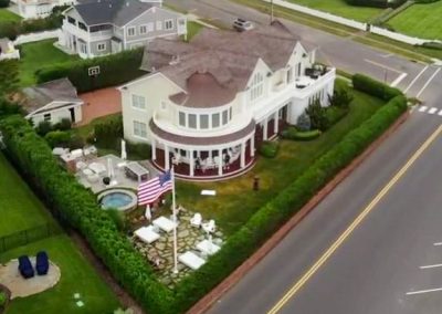 A large white house with an american flag on the roof.